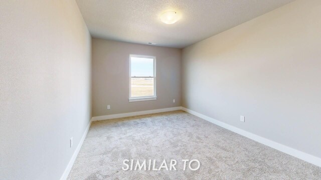 carpeted spare room with a textured ceiling