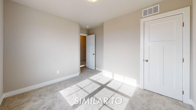 unfurnished bedroom with light colored carpet