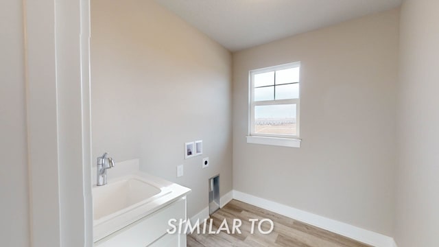 washroom with sink, hookup for a washing machine, light hardwood / wood-style floors, and hookup for an electric dryer