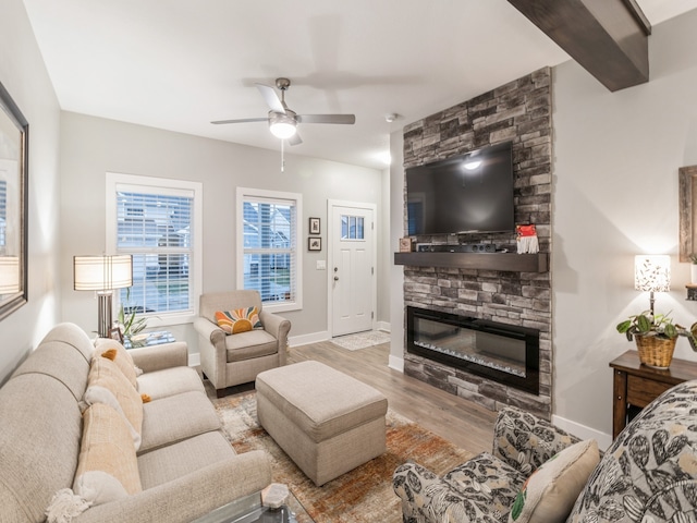 living room with ceiling fan, a fireplace, and light hardwood / wood-style flooring