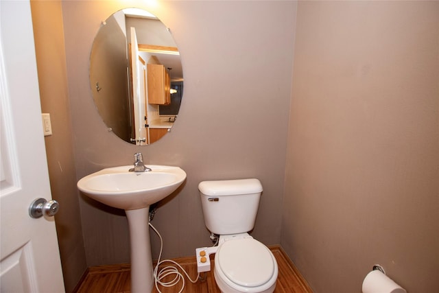 bathroom with hardwood / wood-style flooring, toilet, and sink