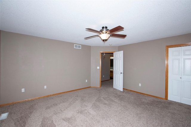 unfurnished bedroom featuring ceiling fan, carpet floors, a textured ceiling, and a closet