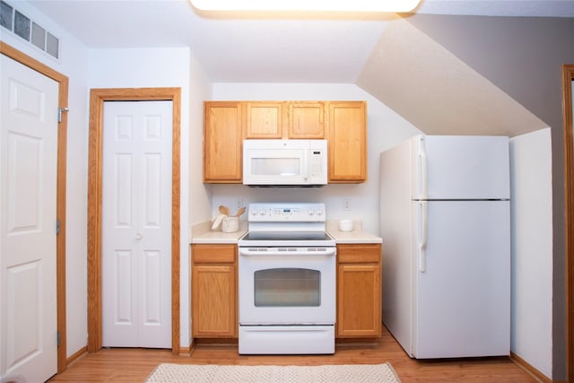 kitchen featuring vaulted ceiling, light brown cabinets, light hardwood / wood-style floors, and white appliances