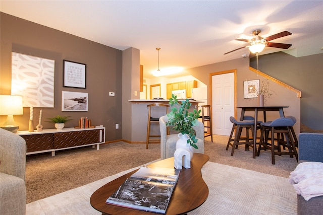 carpeted living room with ceiling fan