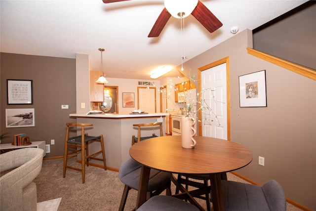 dining space with light carpet and ceiling fan