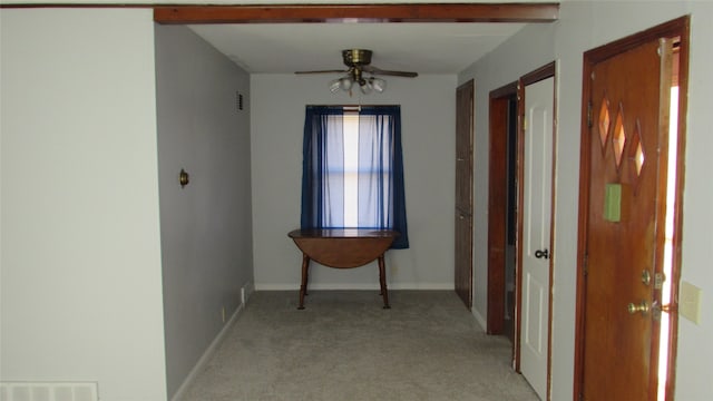 hall with beam ceiling and light carpet