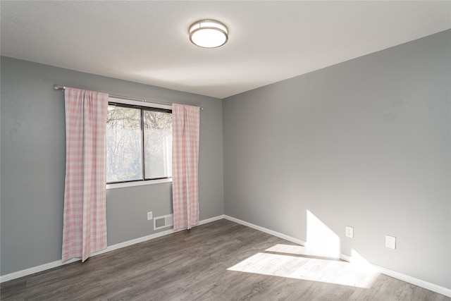 spare room with wood-type flooring