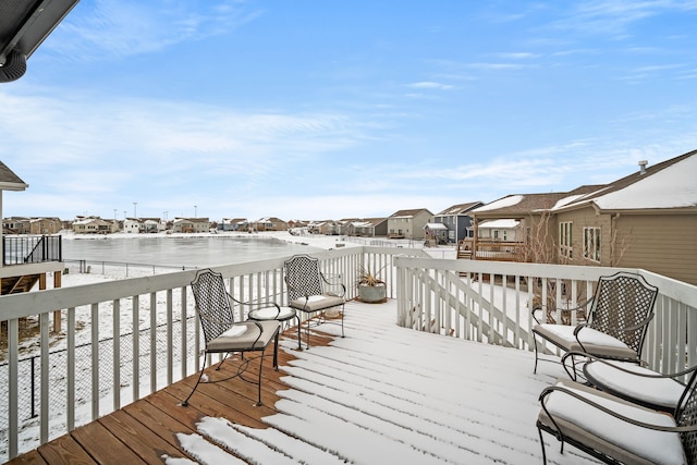 snow covered deck featuring a water view