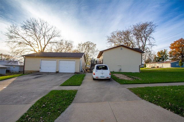 garage at dusk featuring a yard