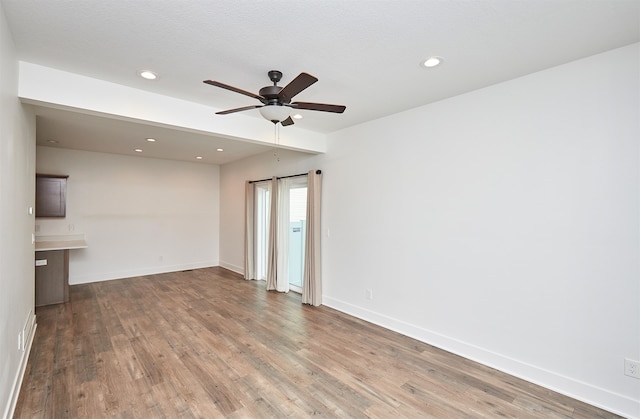 unfurnished room with light wood-type flooring and ceiling fan