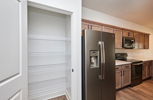 kitchen with stainless steel appliances and light hardwood / wood-style flooring