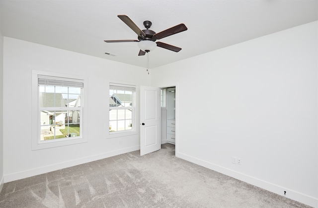 carpeted spare room with ceiling fan