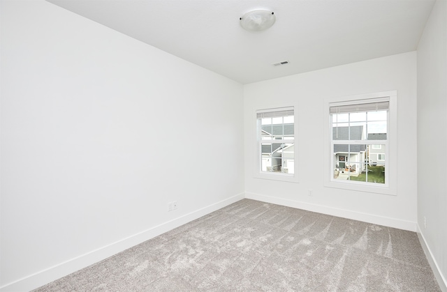 spare room featuring light colored carpet