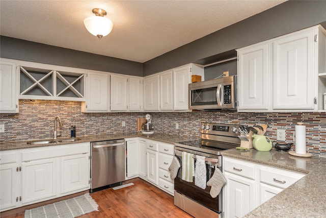 kitchen with stainless steel appliances, white cabinetry, dark hardwood / wood-style floors, and sink