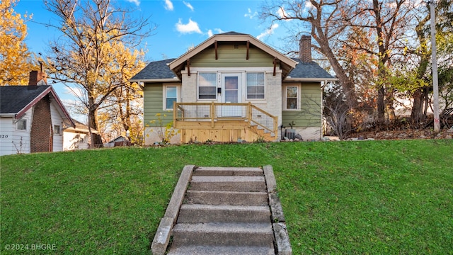 bungalow-style house with central AC unit and a front yard