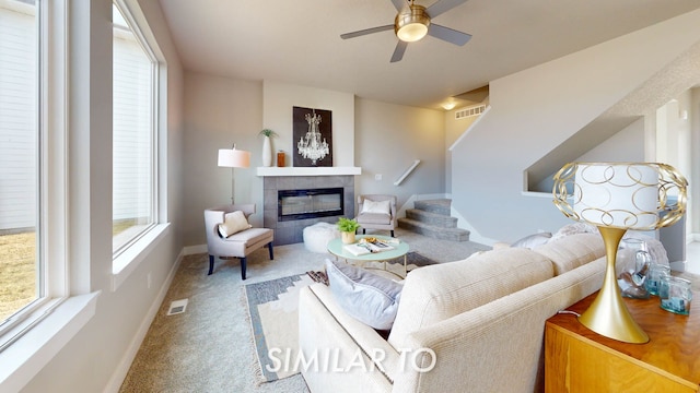 living room with carpet, ceiling fan, and a fireplace