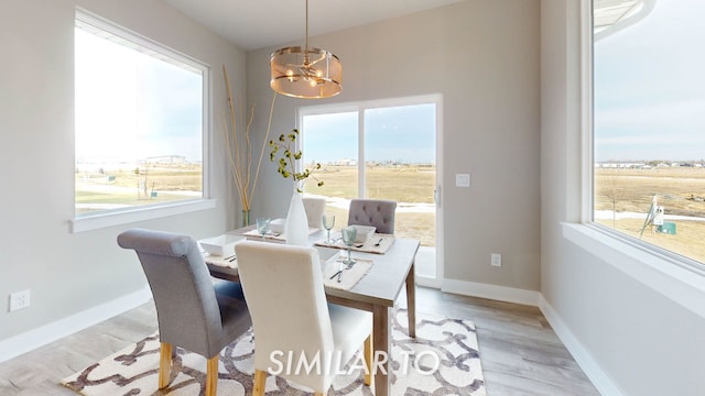 dining area with light hardwood / wood-style flooring and a chandelier