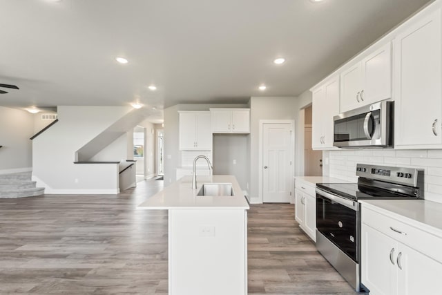 16409 Deerview Dr, Urbandale, IA 50323 - kitchen with baseboards, stainless steel appliances, open floor plan, and a sink