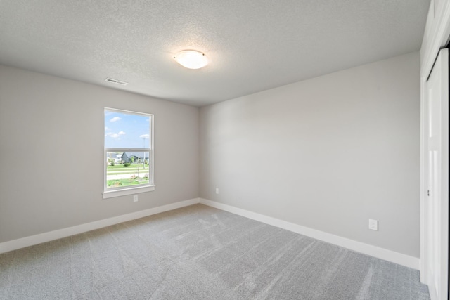 16409 Deerview Dr, Urbandale, IA 50323 - empty room featuring visible vents, a textured ceiling, baseboards, and light carpet