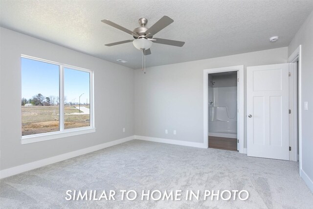 unfurnished bedroom with ceiling fan, ensuite bath, carpet, and a textured ceiling