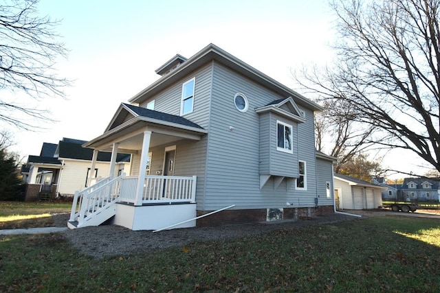 view of side of property with a yard and covered porch