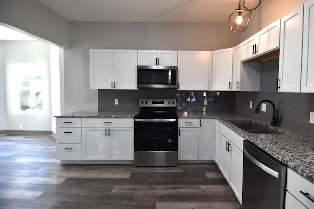 kitchen with sink, appliances with stainless steel finishes, tasteful backsplash, dark hardwood / wood-style flooring, and white cabinetry