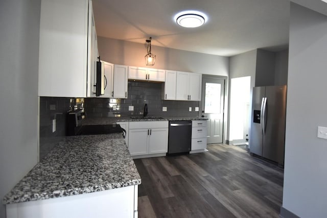 kitchen with stone counters, white cabinetry, stainless steel appliances, and dark hardwood / wood-style floors