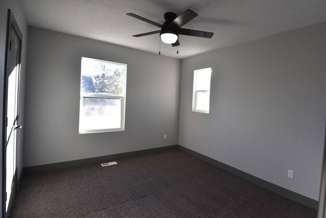 carpeted spare room featuring ceiling fan and a healthy amount of sunlight