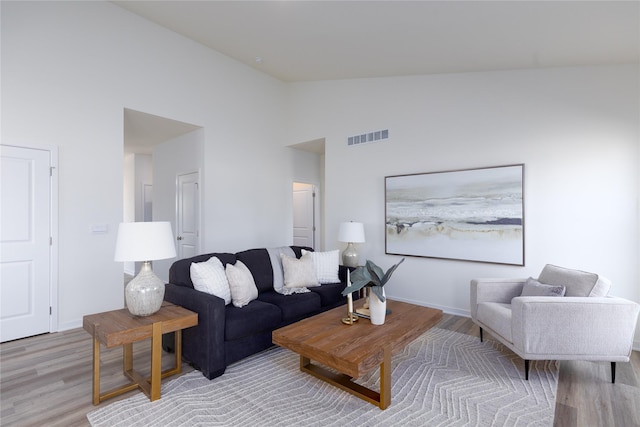 living room with high vaulted ceiling and light hardwood / wood-style flooring