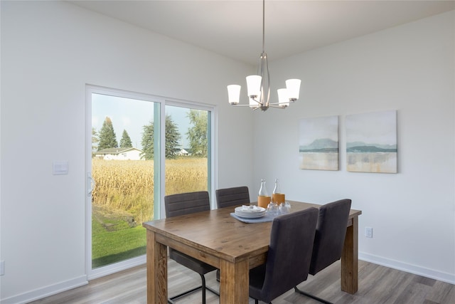 dining space with hardwood / wood-style flooring and a notable chandelier