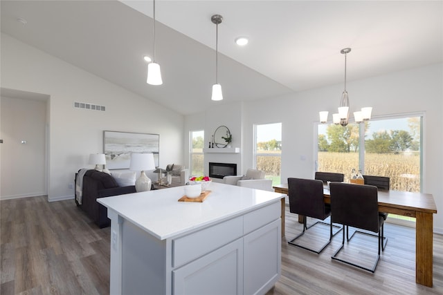 kitchen featuring white cabinetry, hardwood / wood-style floors, pendant lighting, and a center island