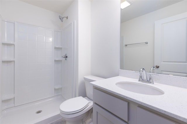 bathroom with toilet, a shower, and vanity