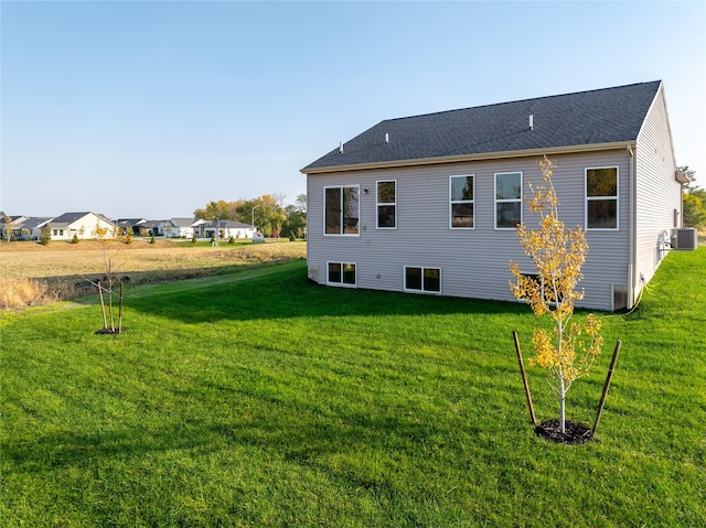 back of house featuring central AC and a lawn