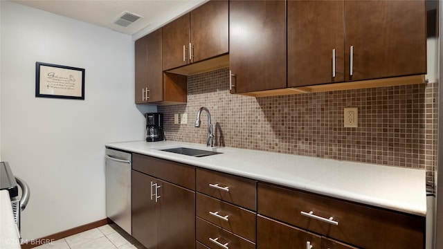 kitchen featuring dark brown cabinetry, dishwasher, sink, backsplash, and light tile patterned floors