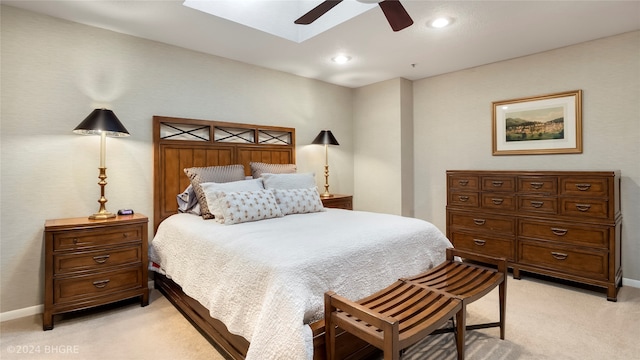 carpeted bedroom featuring a skylight and ceiling fan