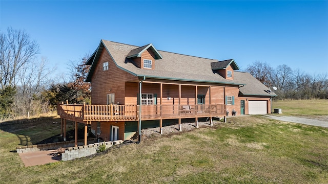 view of front of home featuring a front yard, a garage, and a wooden deck