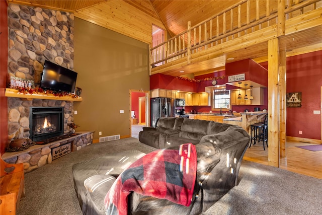 living room with a stone fireplace, high vaulted ceiling, wooden ceiling, and light colored carpet