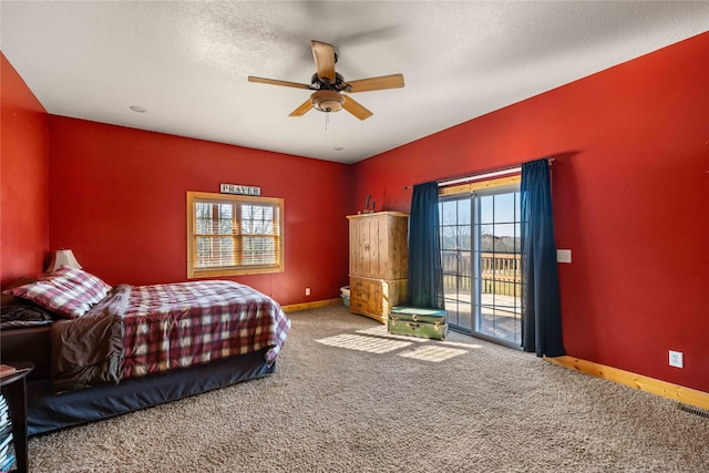 carpeted bedroom with access to exterior, a textured ceiling, and ceiling fan