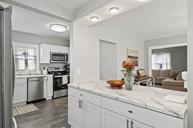 kitchen featuring white cabinetry, stainless steel appliances, and a wealth of natural light