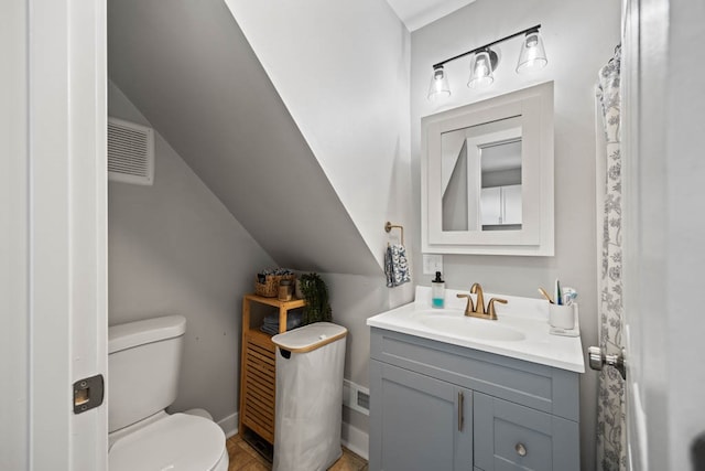 bathroom with vanity, toilet, and vaulted ceiling