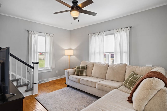 living room with hardwood / wood-style floors, ceiling fan, and ornamental molding