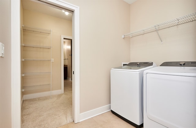 washroom with washing machine and clothes dryer and light tile patterned floors