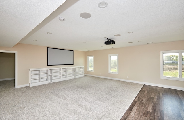 home theater room featuring hardwood / wood-style floors and a textured ceiling