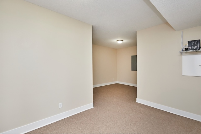 carpeted empty room featuring a textured ceiling and electric panel