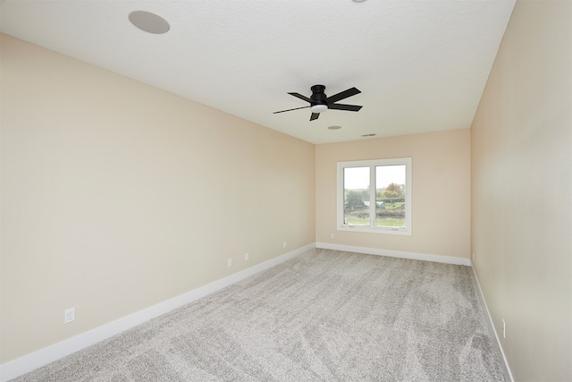 spare room featuring carpet flooring, ceiling fan, and a textured ceiling