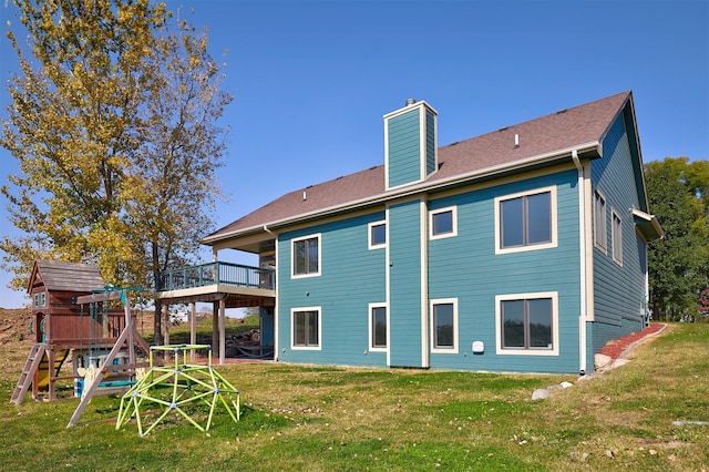 back of property featuring a lawn, a playground, and a wooden deck