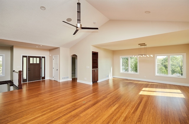 unfurnished living room with ceiling fan, high vaulted ceiling, and hardwood / wood-style flooring