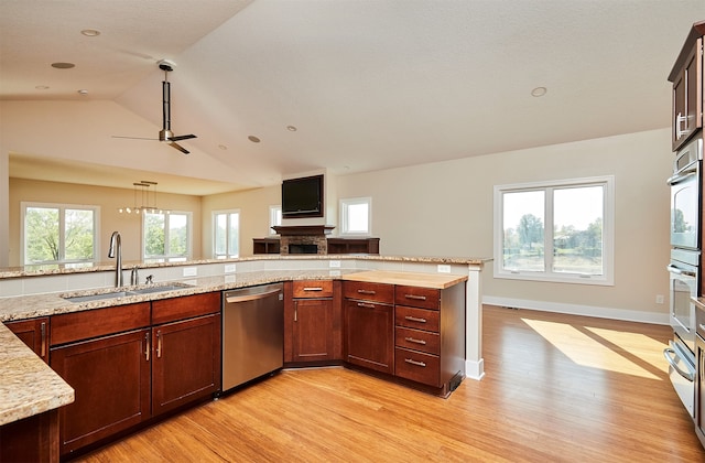 kitchen featuring ceiling fan, sink, dishwasher, light hardwood / wood-style flooring, and lofted ceiling