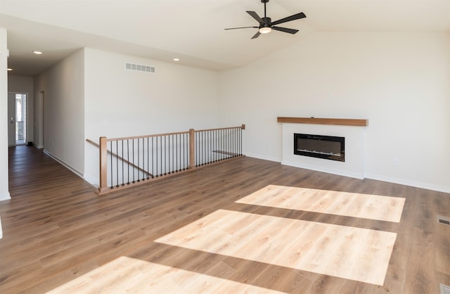 unfurnished living room featuring ceiling fan, wood-type flooring, and vaulted ceiling