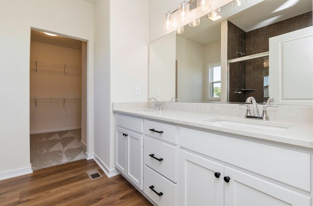 bathroom featuring vanity, hardwood / wood-style flooring, and a shower with shower door